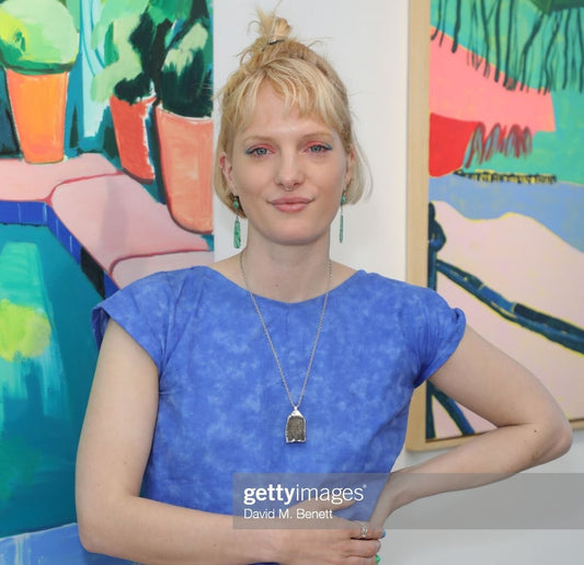 Photo of Lucy Smallbone with her artwork in background
